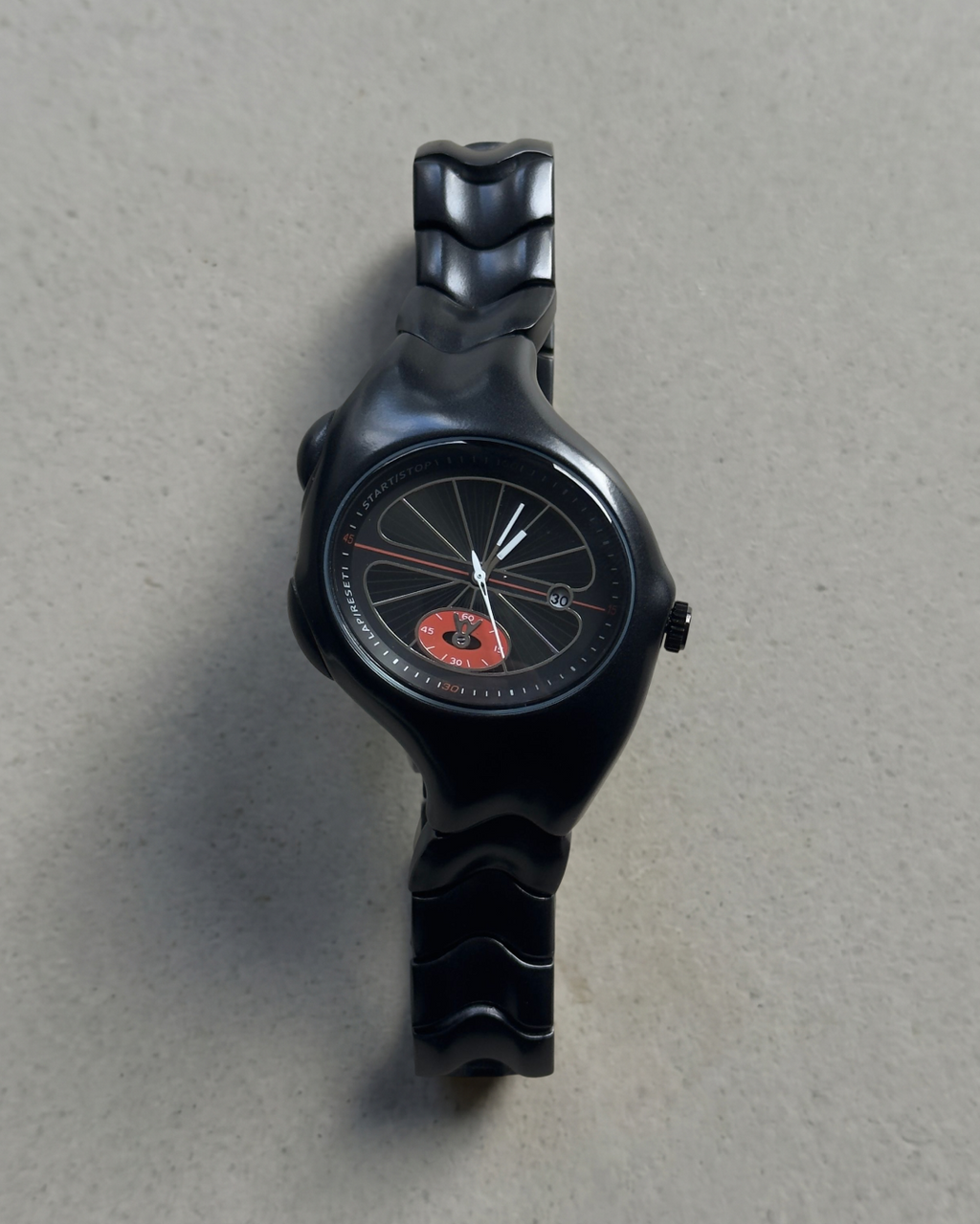 Black track wristwatch with unique Y2K design on a gray background