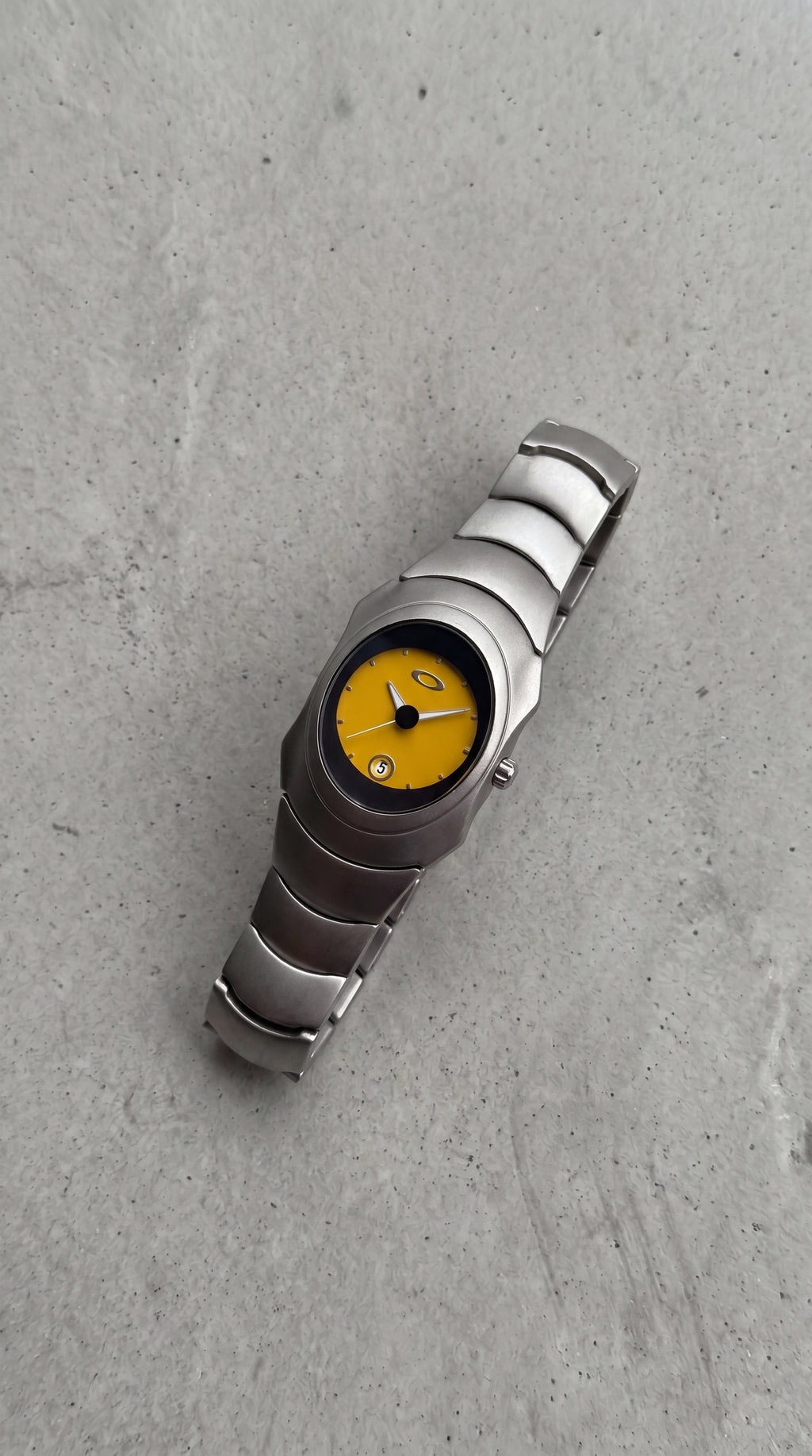 Unique Yellow dial Y2K, 2000s steel metal watch on a clean grey concrete surface