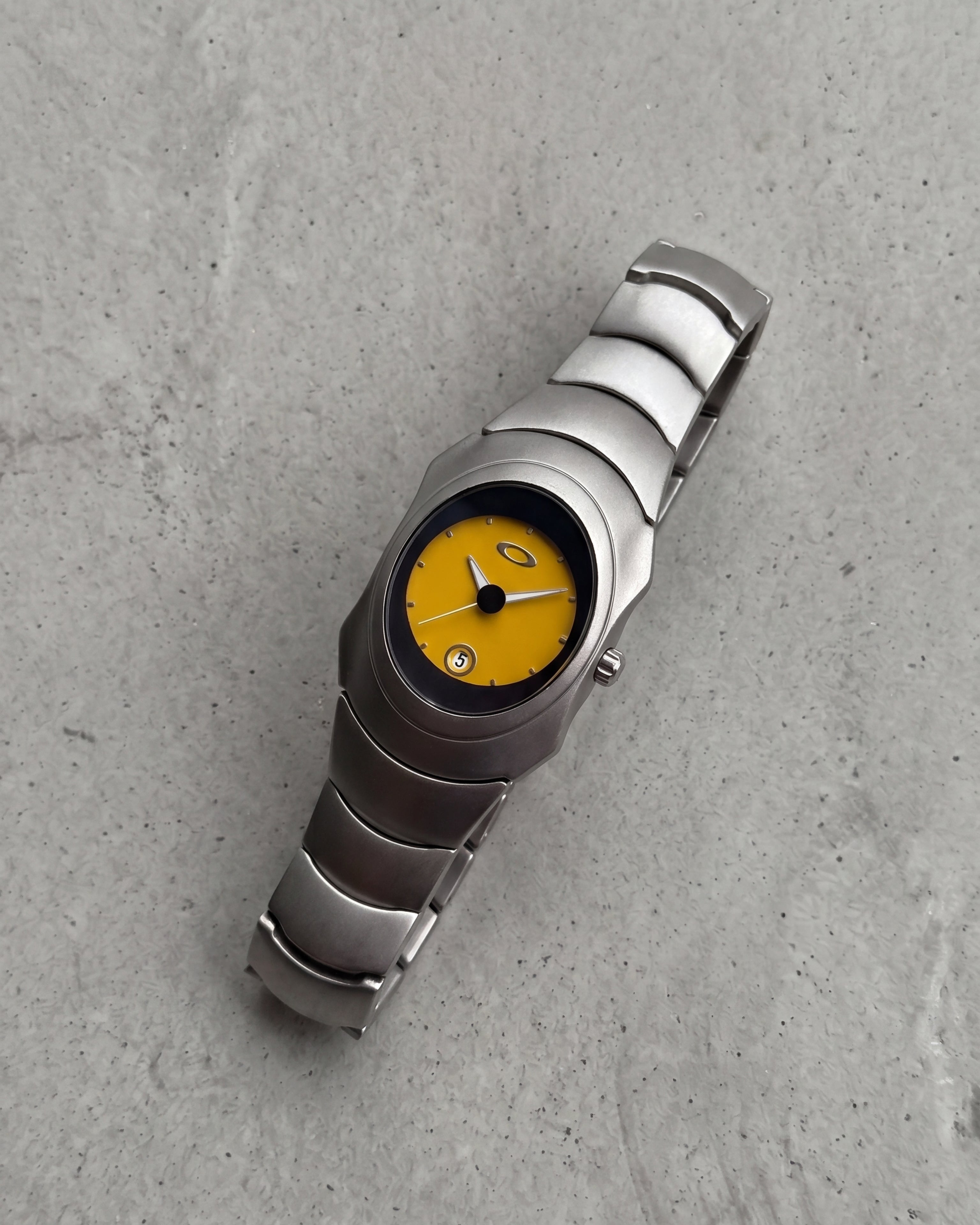 Unique Yellow dial Y2K, 2000s steel metal watch on a clean grey concrete surface