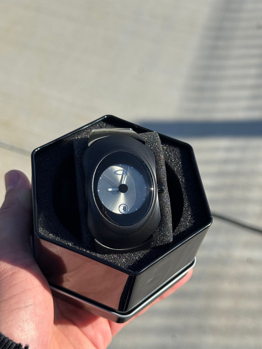 Matte black Y2K watch held in hand, Aerostore Time Bomb Midnight Black colourway with sculpted stainless steel case showing alien-inspired curves typical of 2000s wristwatch design